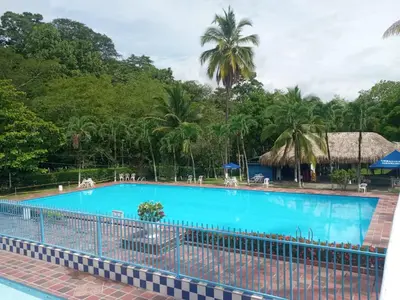 a large blue swimming pool with trees in the background at Cabaña 2 Montenegro La Pintada in La Pintada