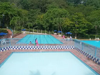 an empty swimming pool with people in the water at Cabaña 2 Montenegro La Pintada in La Pintada