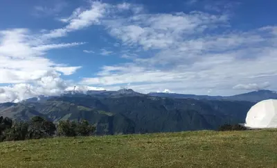 a field with a view of a mountain at Fabrica de Rios Glamping in Manizales