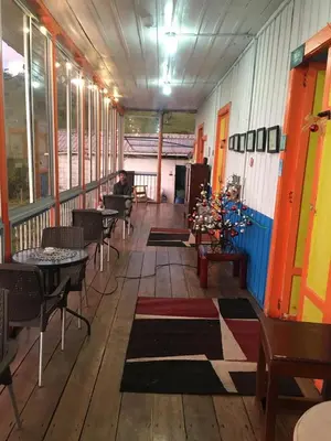 a room with tables and chairs and a person sitting at a table at Fabrica de Rios Glamping in Manizales