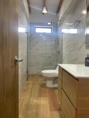 a bathroom with a toilet and a glass shower at Serenity house Guatapé in Guatapé