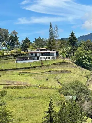 a house on top of a grassy hill at Serenity house Guatapé in Guatapé