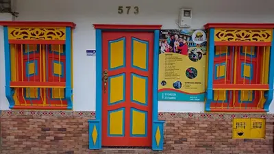 a building with colorful doors on the side of it at TURISTAS Hostel in Jardin