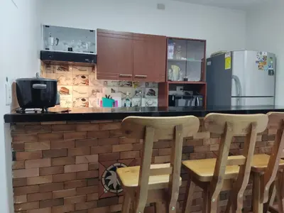 a kitchen with a counter with chairs and a refrigerator at TURISTAS Hostel in Jardin