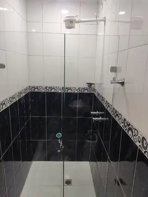 a bathroom with a shower with black and white tiles at TURISTAS Hostel in Jardin