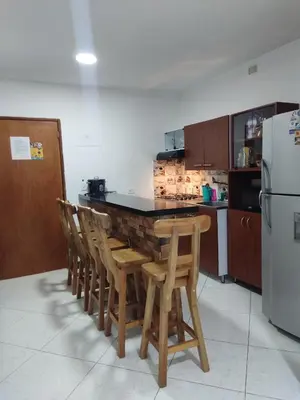 a kitchen with a table and chairs and a refrigerator at TURISTAS Hostel in Jardin