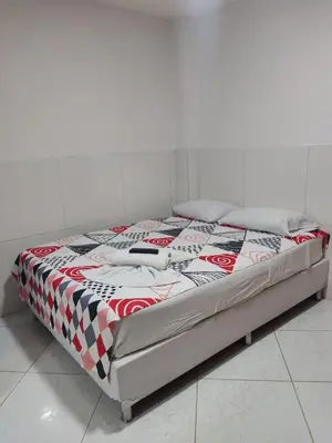 a bed in a white room with at TURISTAS Hostel in Jardin