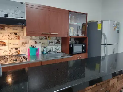 a kitchen with a black counter top and a refrigerator at TURISTAS Hostel in Jardin