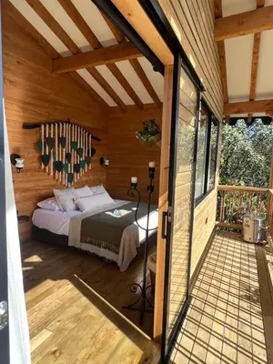a bedroom with a bed in a wooden house at refugio amazonico in Rionegro