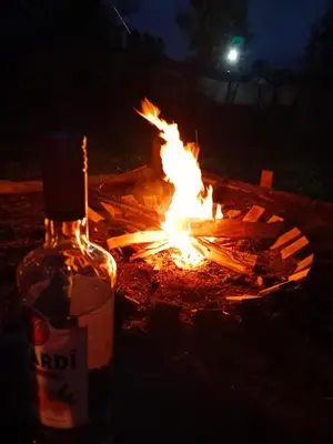 a bottle of alcohol sitting next to a fire at refugio amazonico in Rionegro