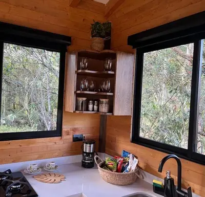 a kitchen with two windows in a log cabin at refugio amazonico in Rionegro