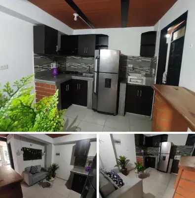 a kitchen with black cabinets and a kitchen with plants at Apartamento en Itagüí in Itagüí