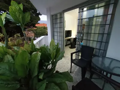a balcony with a glass table and chairs and plants at Acogedor Loft con Balcones para 2H Belén Rosales apt 201 in Medellín