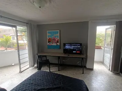 a bedroom with a desk with a computer on it at Acogedor Loft con Balcones para 2H Belén Rosales apt 201 in Medellín