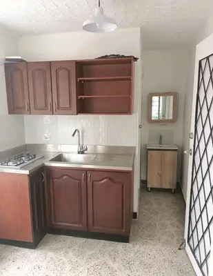 a kitchen with wooden cabinets and a sink at Acogedor Loft con Balcones para 2H Belén Rosales apt 201 in Medellín