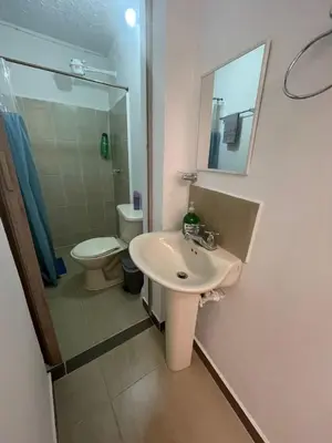 a bathroom with a sink and a toilet and a mirror at Acogedor Aparta Hotel para 3H Belén Rosales apt 202 in Medellín