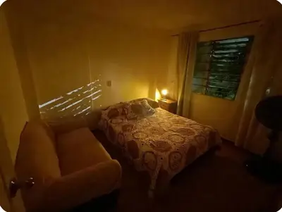 a bedroom with a bed and a couch and a window at Acogedor Aparta Hotel para 3H Belén Rosales apt 202 in Medellín