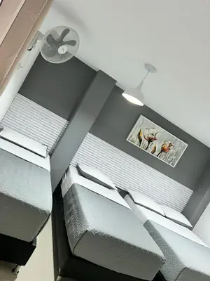 a room with three beds and a ceiling at Hotel Lesus in Medellín
