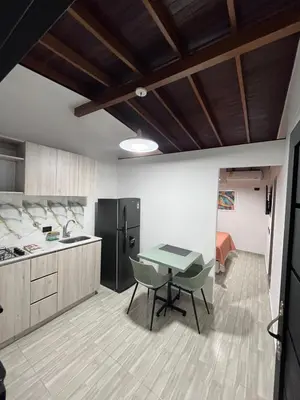 a kitchen with a table and chairs in a room at Hotel Lesus in Medellín