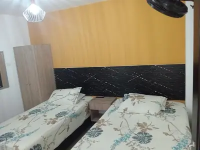two beds in a room with yellow walls at Hotel Lesus in Medellín