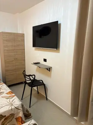 a room with a chair and a television on a wall at Hotel Lesus in Medellín