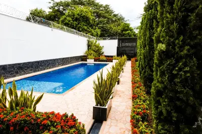 a swimming pool in a garden with flowers and plants at Casa Finca La Nana in San Jerónimo