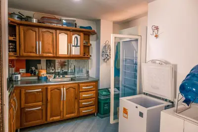 a kitchen with wooden cabinets and a white refrigerator at Casa Finca La Nana in San Jerónimo