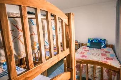 a wooden bunk bed with a bed in a room at Casa Finca La Nana in San Jerónimo