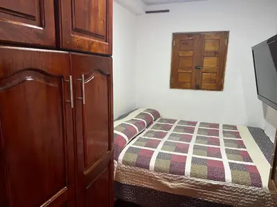 a small bedroom with a bed and a cabinet at En la Zona Rosa, a una cuadra del Parque in Urrao
