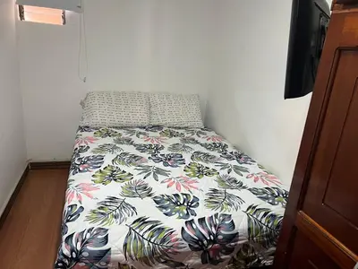 a bed with a floral comforter in a bedroom at En la Zona Rosa, a una cuadra del Parque in Urrao