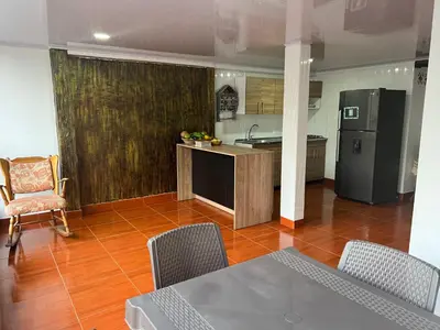 a kitchen with a refrigerator and a table and chairs at En la Zona Rosa, a una cuadra del Parque in Urrao