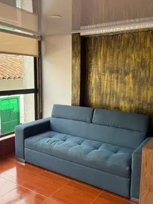 a blue couch sitting in a living room at En la Zona Rosa, a una cuadra del Parque in Urrao