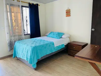 a small bedroom with a bed and a window at Cabaña Campestre EN RIO CLARO- Doradal, Antioquia in Mesa del Norte