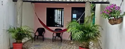 a porch with two chairs and a hammock in a house at Cabaña Campestre EN RIO CLARO- Doradal, Antioquia in Mesa del Norte