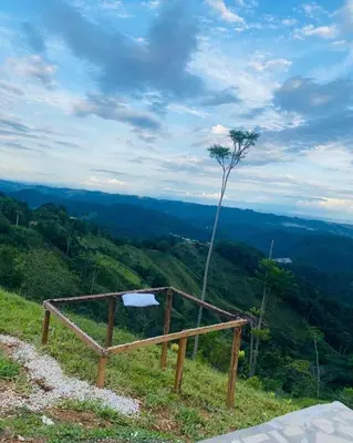 a bench on a hill with a tree on it at Cabaña Campestre EN RIO CLARO- Doradal, Antioquia in Mesa del Norte