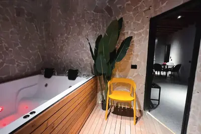 a yellow chair sitting next to a tub with a plant at URBAN COMFORT POBLADO SUIT's in Medellín