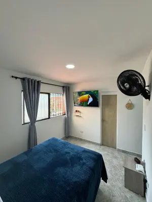a bedroom with a blue bed and a window at Casa San Miguel 101 in Medellín