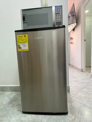 a microwave oven sitting on top of a refrigerator at Casa San Miguel 101 in Medellín