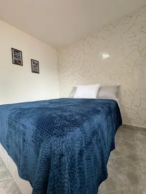 a bedroom with a bed with a blue blanket on it at Casa San Miguel 101 in Medellín