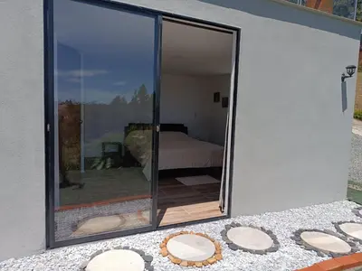 a room with a sliding glass door with a bed at Cabaña Estancia Primavera in Guatapé