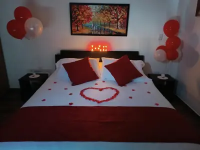 a bed with a heart made out of red pillows at Cabaña Estancia Primavera in Guatapé
