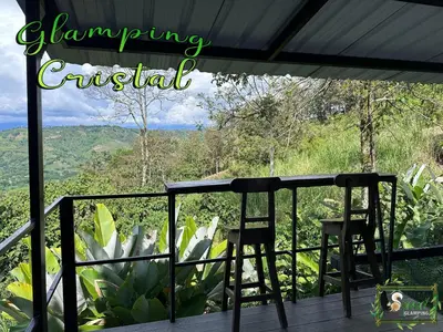 a balcony with two chairs and a view of the mountains at Saray glamping in Palestina