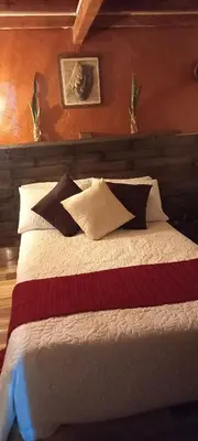 a bedroom with a large bed with pillows at Boresta House -Santa Elena con vista al Bosque y terraza privada in Medellín