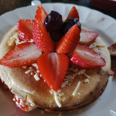 a stack of pancakes with strawberries on a plate at Boresta House -Santa Elena con vista al Bosque y terraza privada in Medellín