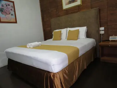a bedroom with a large bed with yellow and white pillows at Hotel El Tesoro Sonson in Sonsón