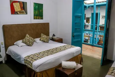 a bedroom with a bed and a blue door at Hotel El Tesoro Sonson in Sonsón