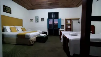a hotel room with two beds in a room at Hotel El Tesoro Sonson in Sonsón