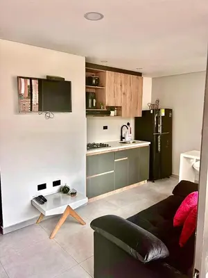 a living room with a couch and a kitchen at Apartamento Premium Sabaneta in Sabaneta
