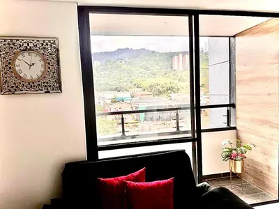 a room with a large window with a clock on the wall at Apartamento Premium Sabaneta in Sabaneta