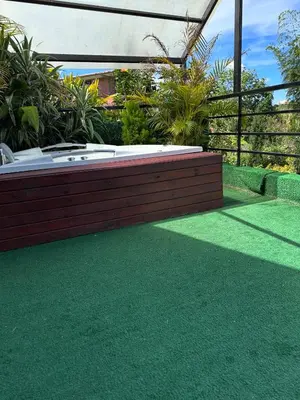 a hot tub in a garden with green grass at Finca hotel xamai in Guatapé